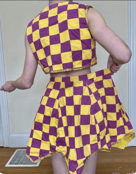 A woman wearing a lilac and yellow outfit