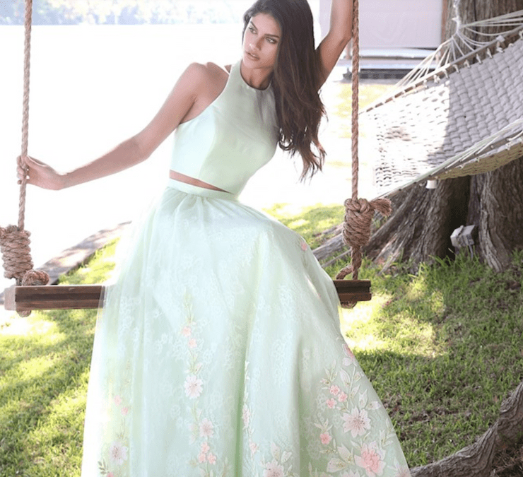 A woman wearing a sage green Sherri Hill dress